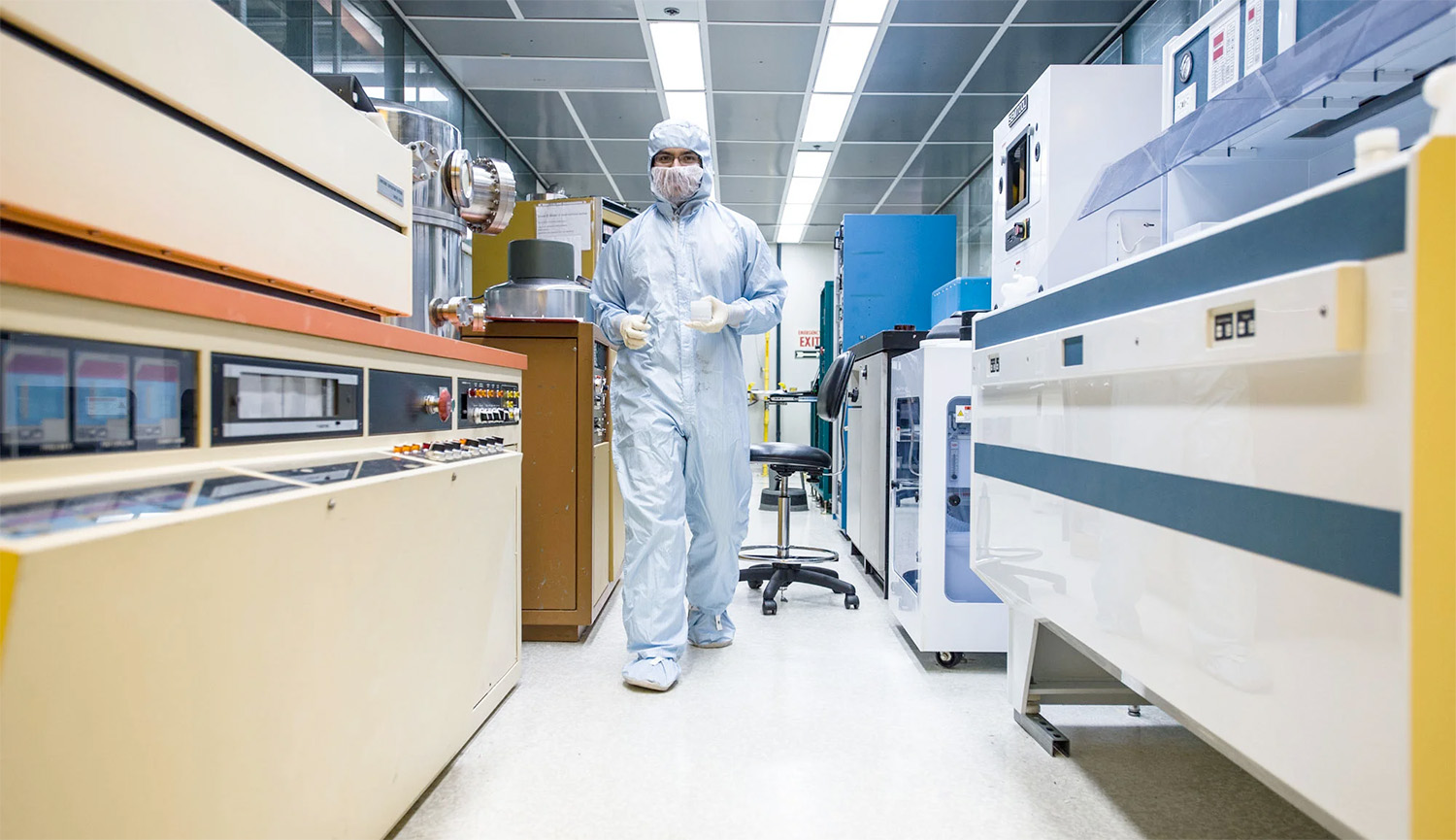 Student in clean room uniform walking through facility