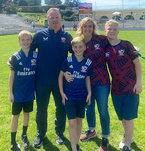Kelly Ashfield poses with her husband and three boys on a rugby pitch