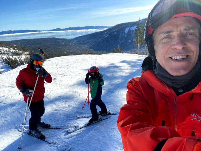 Jonathan Curtis poses with friends while skiing on a mountain