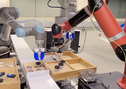 Robotic arms assembling and testing components on a workbench in an automation and robotics laboratory.